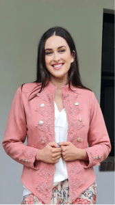 Austere Suede Touch Jacket in blush , featuring intricate lace detailing along the front and cuffs, adorned with gold buttons for a refined, elegant finish.