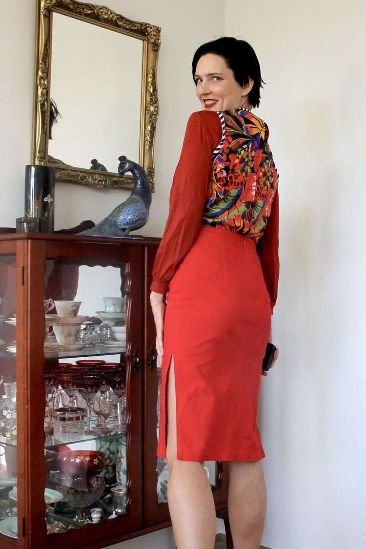 Red pencil skirt paired with a colorful floral blouse featuring voluminous sleeves.