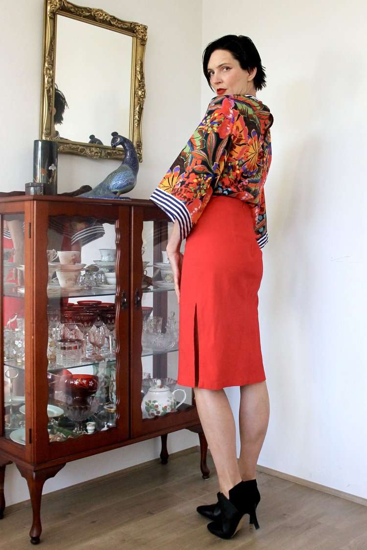 Red pencil skirt paired with a colorful floral blouse featuring voluminous sleeves.