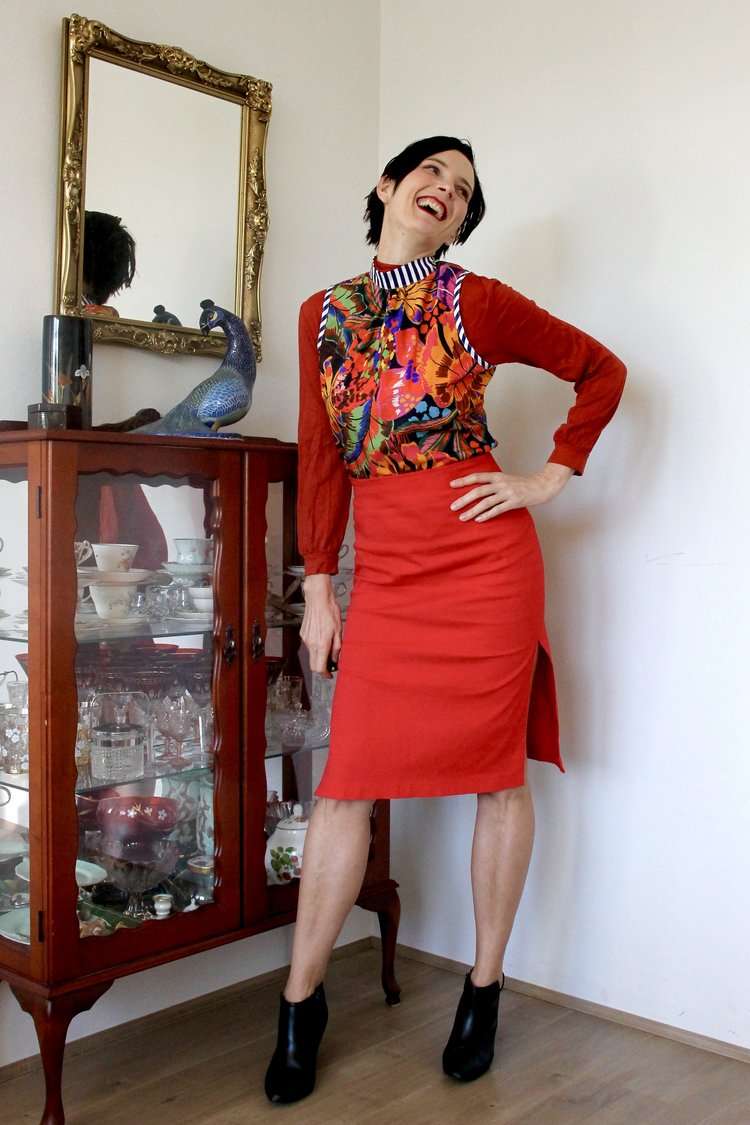 Red pencil skirt paired with a colorful floral blouse featuring voluminous sleeves.
