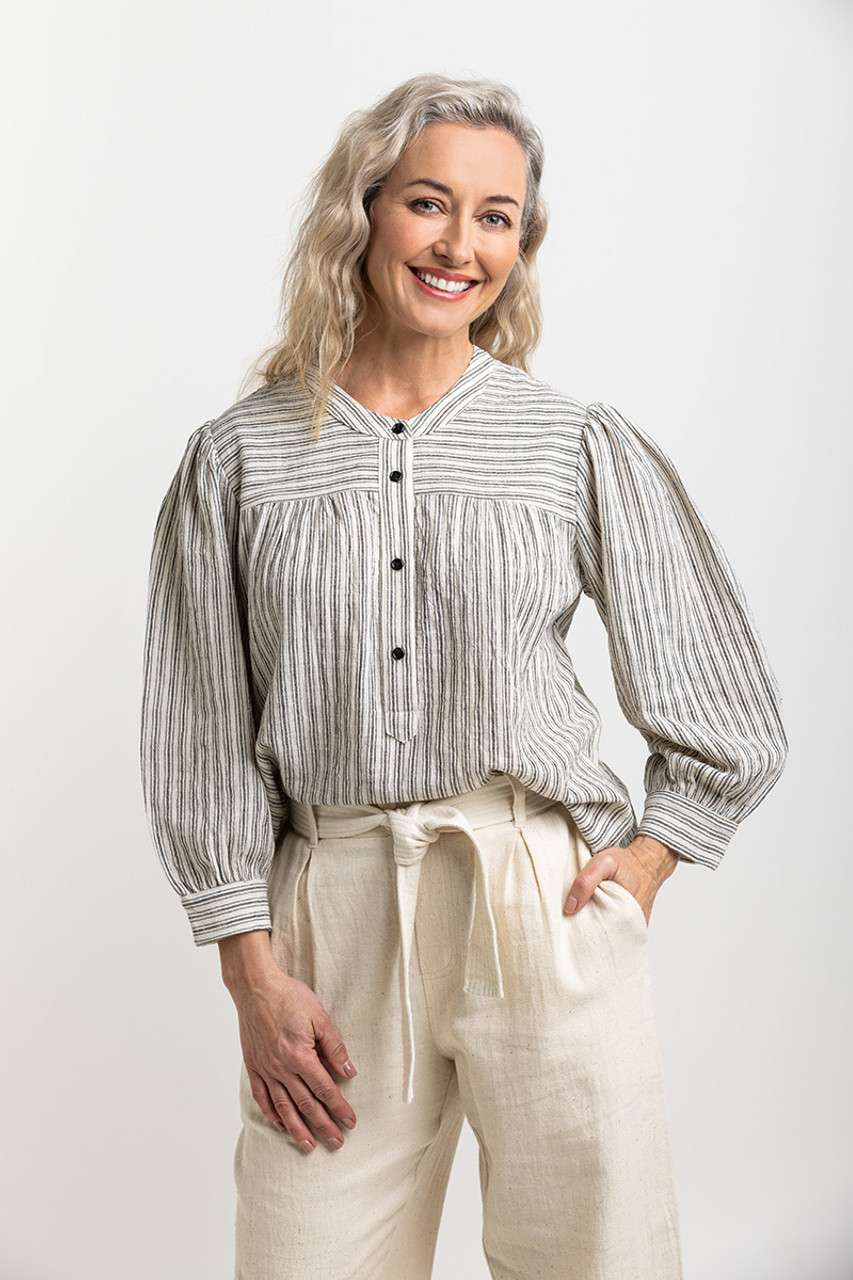 Natural-toned striped blouse with black buttons, featuring gathered details at the yoke, emphasizing Colouron Cotton's slow fashion values.