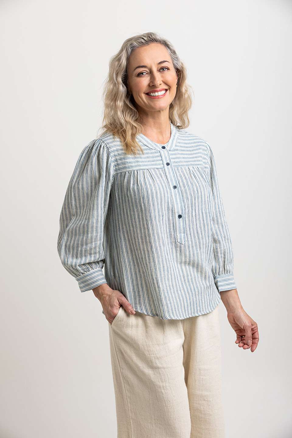 Light blue and white striped blouse with a partial button placket, loose fit, crafted from eco-friendly materials by Colouron Cotton.