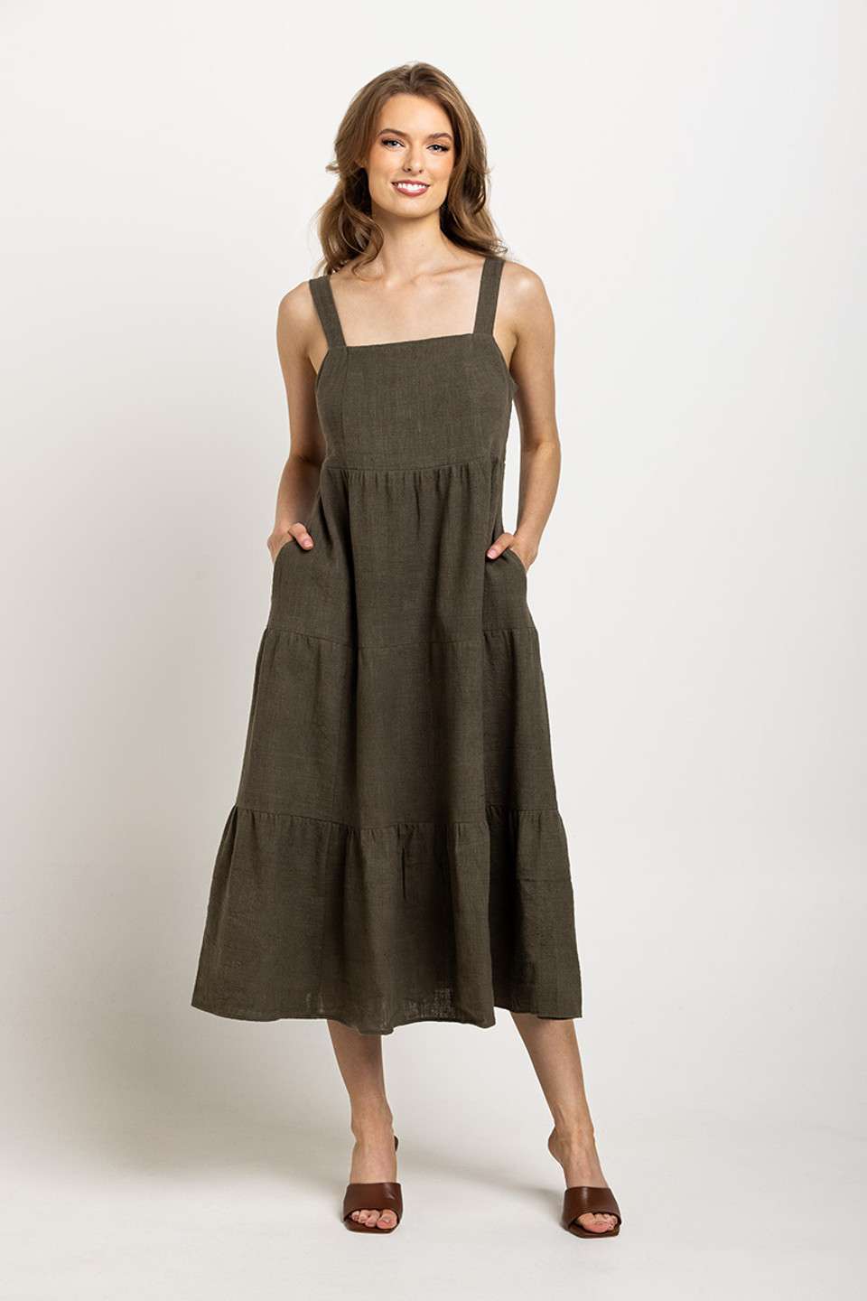 Deep olive tiered dress with a square neckline and pockets, emphasizing Colouron Cotton's slow fashion values.