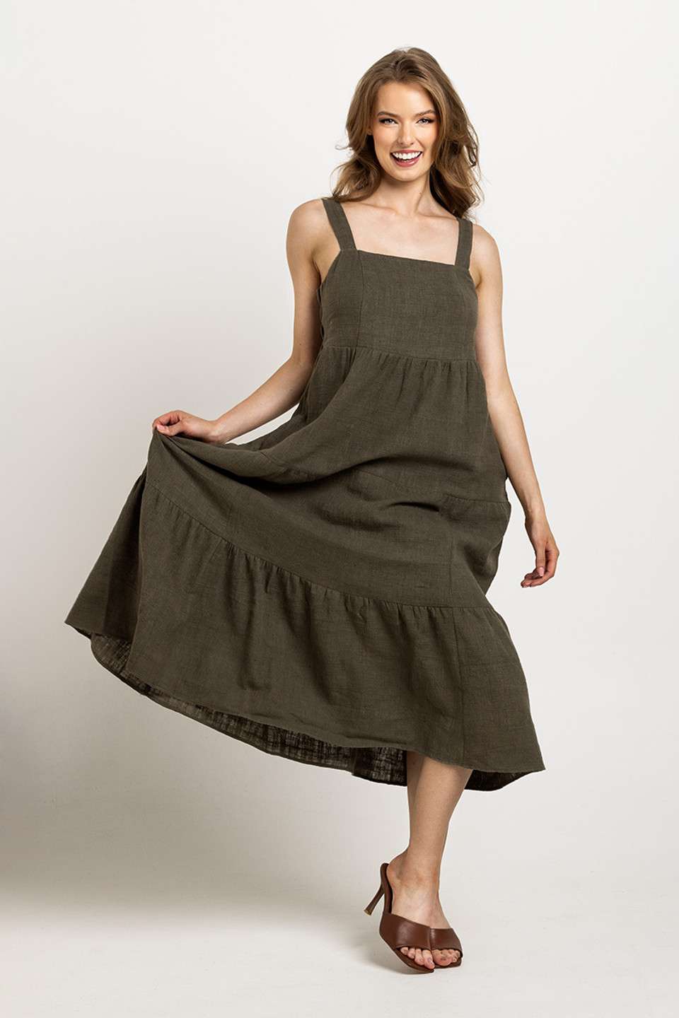 Deep olive tiered dress with a square neckline and pockets, emphasizing Colouron Cotton's slow fashion values.