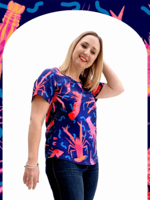 A close-up view of a textile print depicting pink and red crustaceans, including lobsters and shrimp, on a deep blue background, with wavy line details that give a playful, underwater feel. Designed by Australian designer brand Streborclothing.
