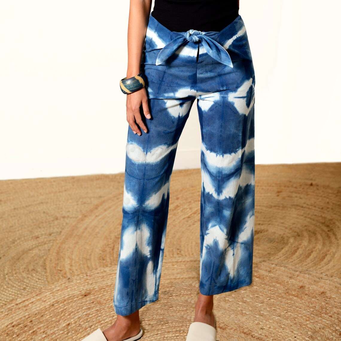 Blue and white Shibori-dyed pants with bold patterns, designed by Lava using plant-based natural textiles