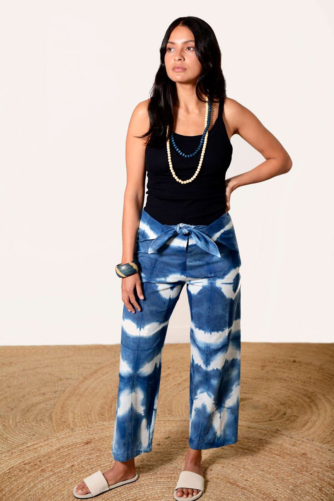Blue and white Shibori-dyed pants with bold patterns, designed by Lava using plant-based natural textiles