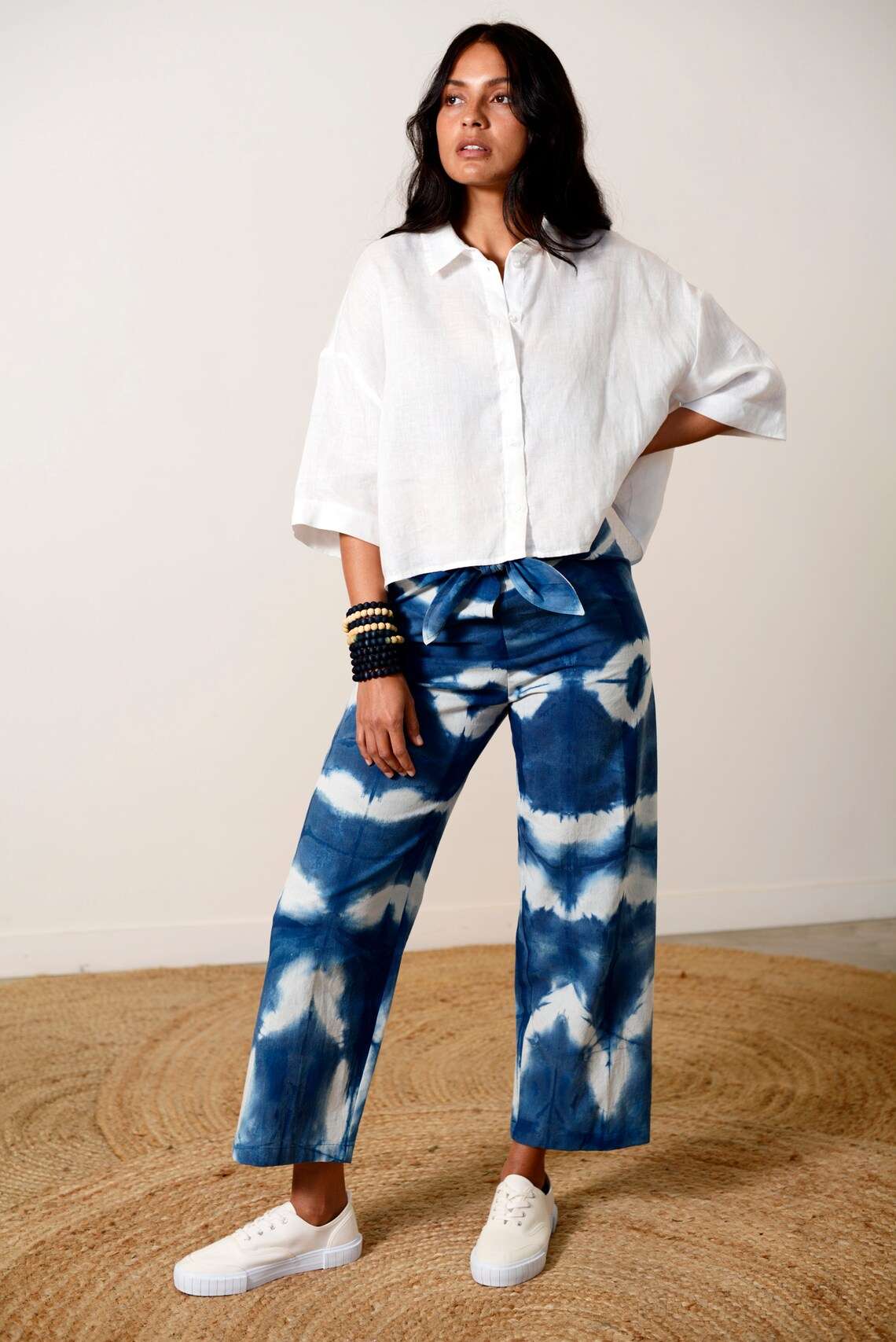 Blue and white Shibori-dyed pants with bold patterns, designed by Lava using plant-based natural textiles
